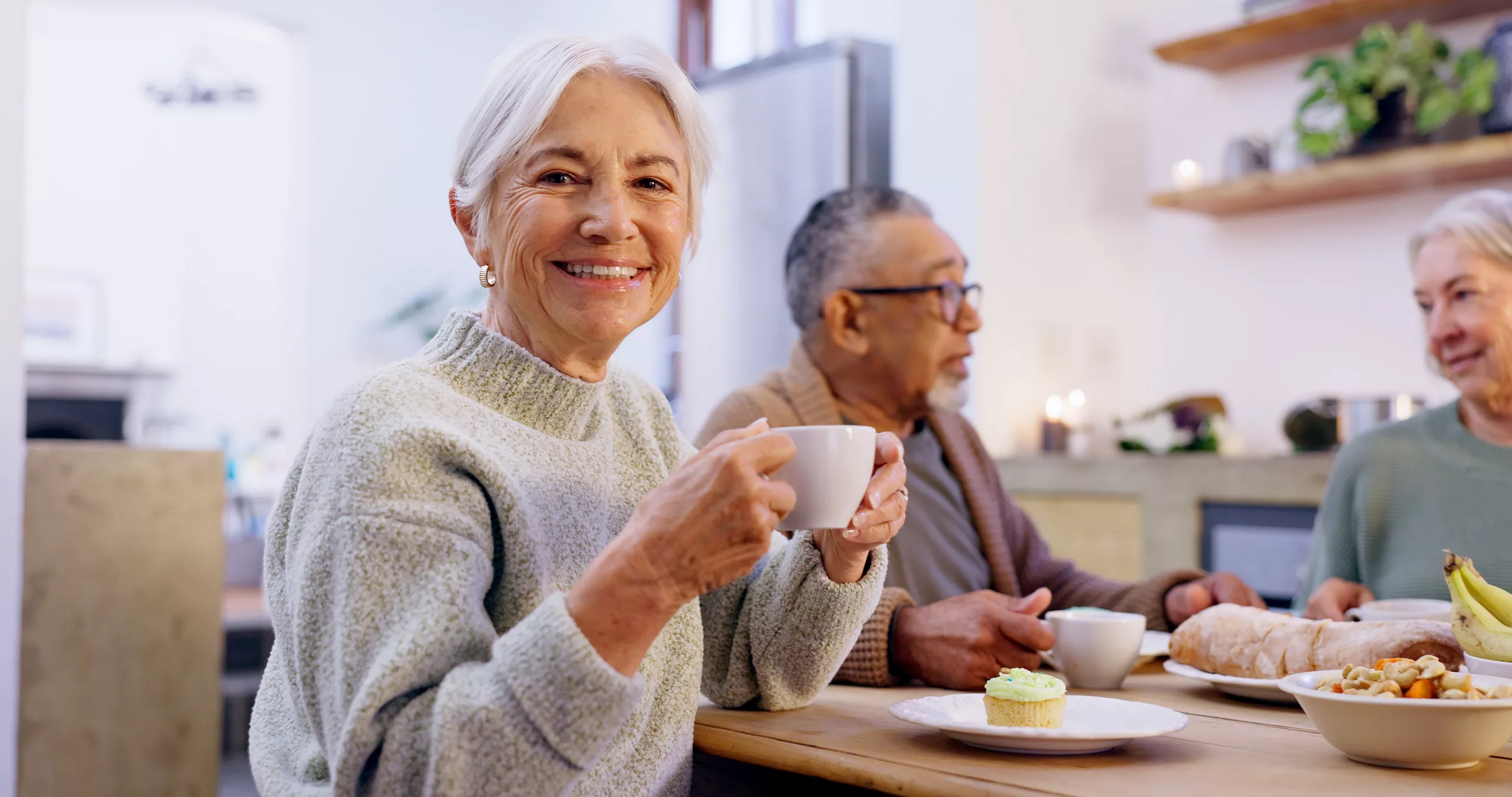 Bewohnerin der Tagespflege von Leusbrock Pflege trinkt einen Kaffee bei guter Stimmung.