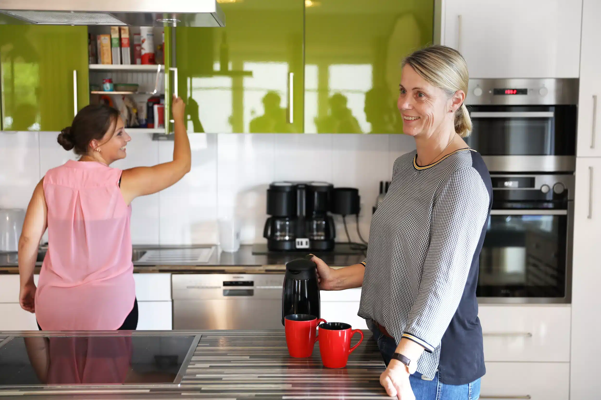 Zwei Pflegekräfte stehden in der Küche in der Tagespflegeeinrichtung der Firma Leusbrock Pflege.